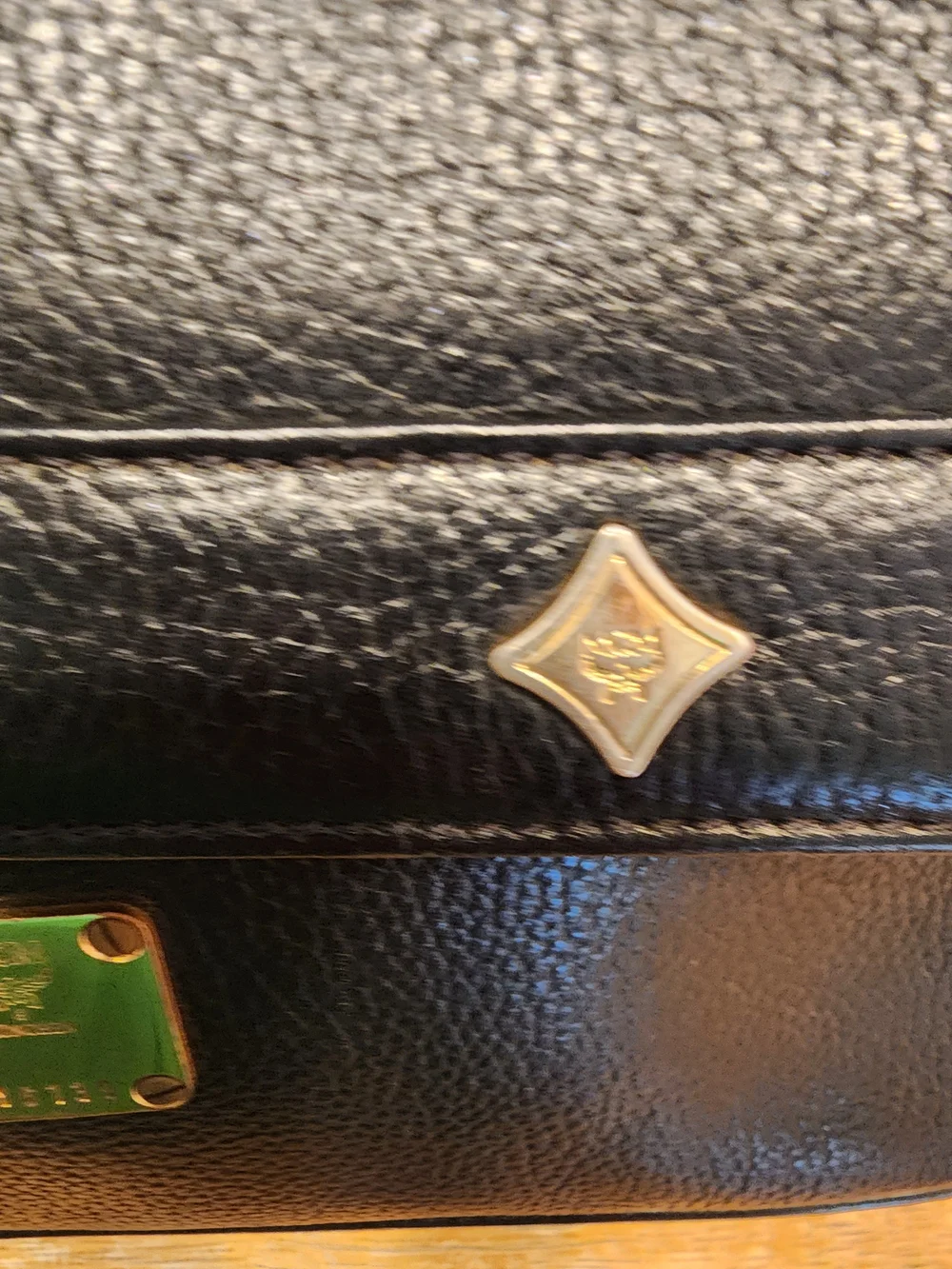 vintage MCM black pebbled leather studded crossbody bag featuring a front plaque